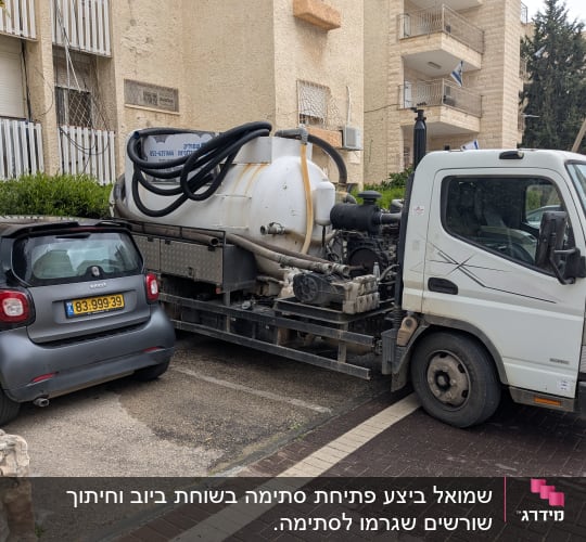 משאית שאיבה עם מיכל גדול וצינורות שחורים